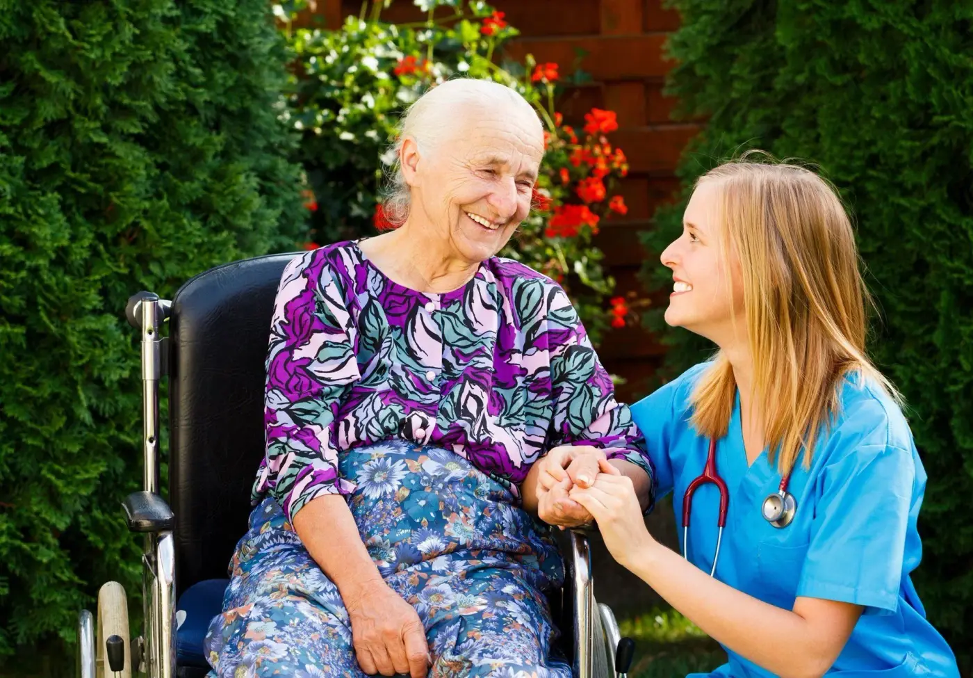 Kind nurse talking to elderly woman outside